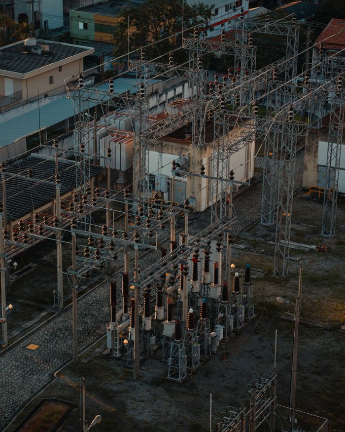 brand-01 A detailed aerial view of a bustling electrical substation, showcasing industrial infrastructure.